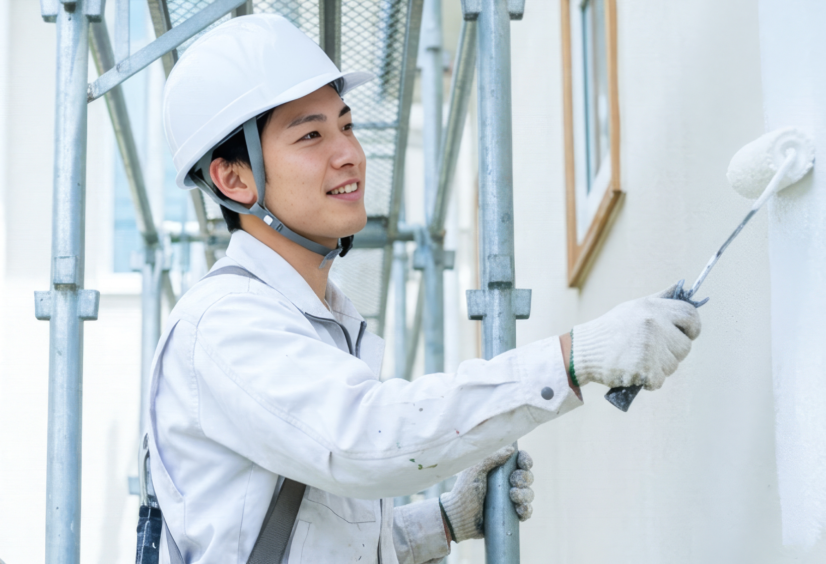 戸建て住宅の外壁を塗装する職人